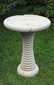 A bird bath with a ringed pedestal